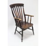 A Victorian lath-back elbow chair with hard seat, & on turned legs with plain stretchers.