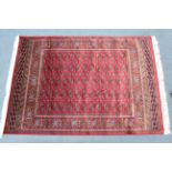 A Bokhara rug of crimson ground with five rows of thirteen guhls to centre within a wide border, 76”