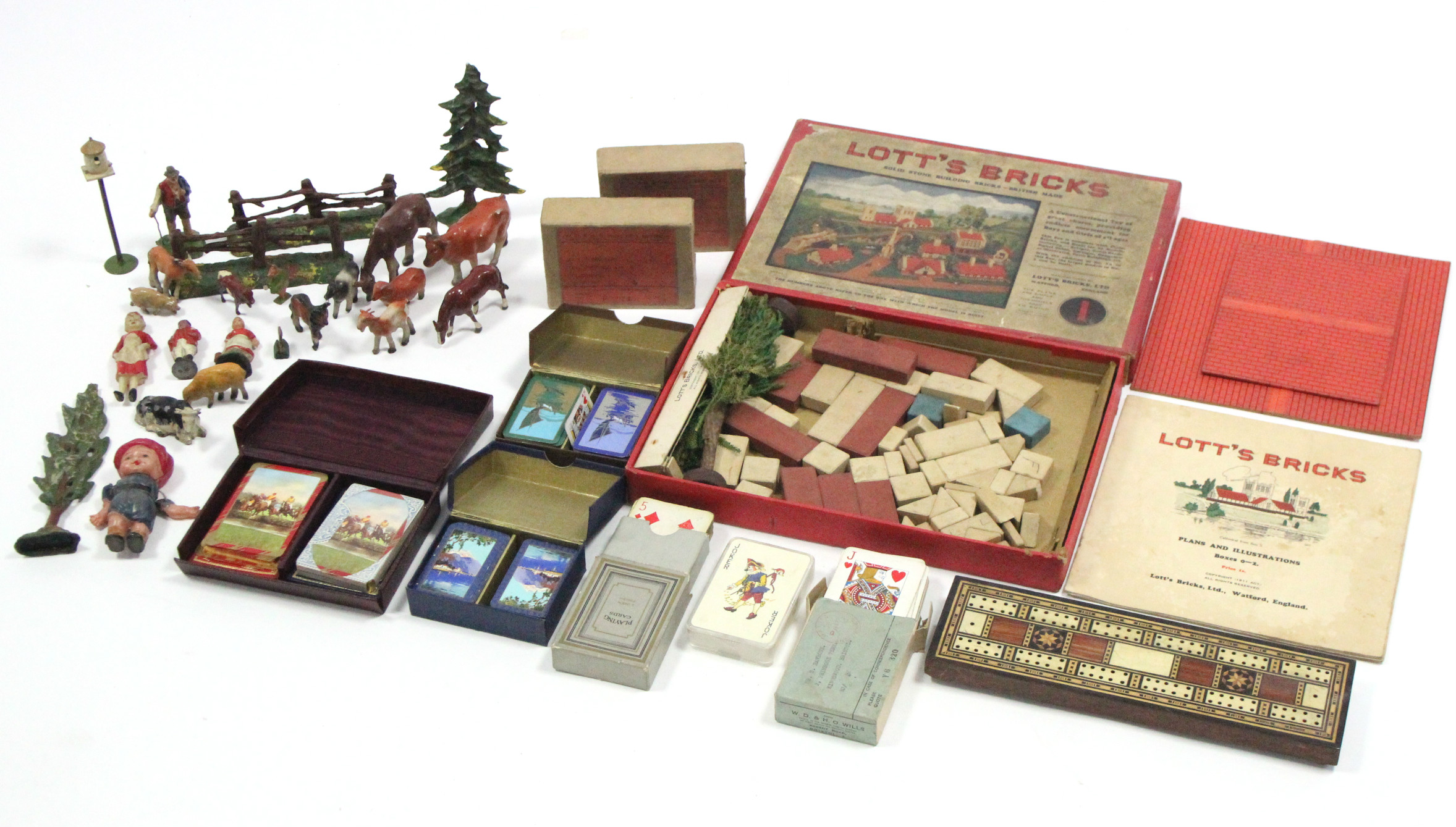 A Lott’s Bricks “No. 1” construction set, boxed; a cribbage board; & six sets of playing cards.