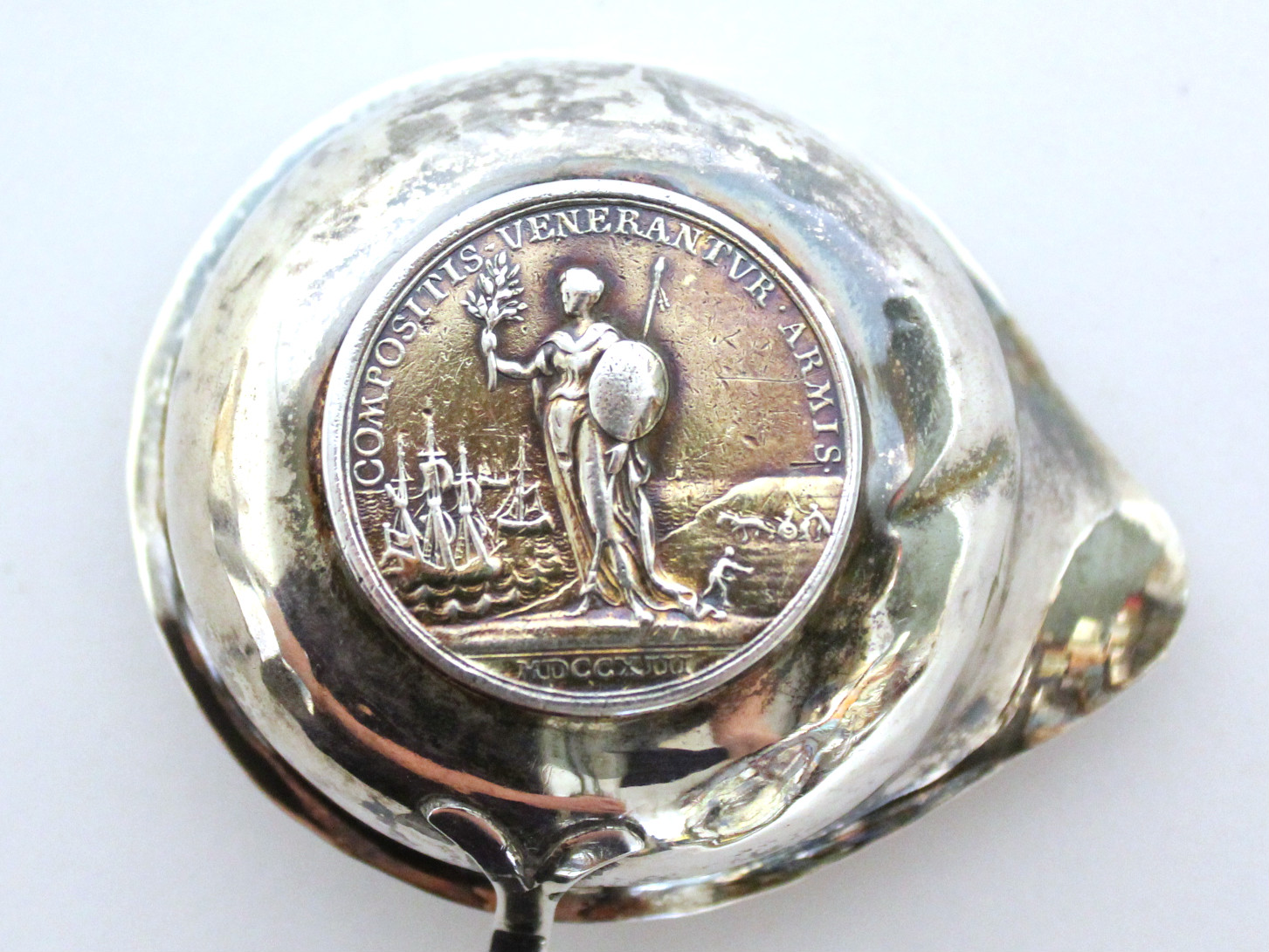 An 18th century punch ladle, the round single-lipped bowl inset Queen Anne medal commemorating the