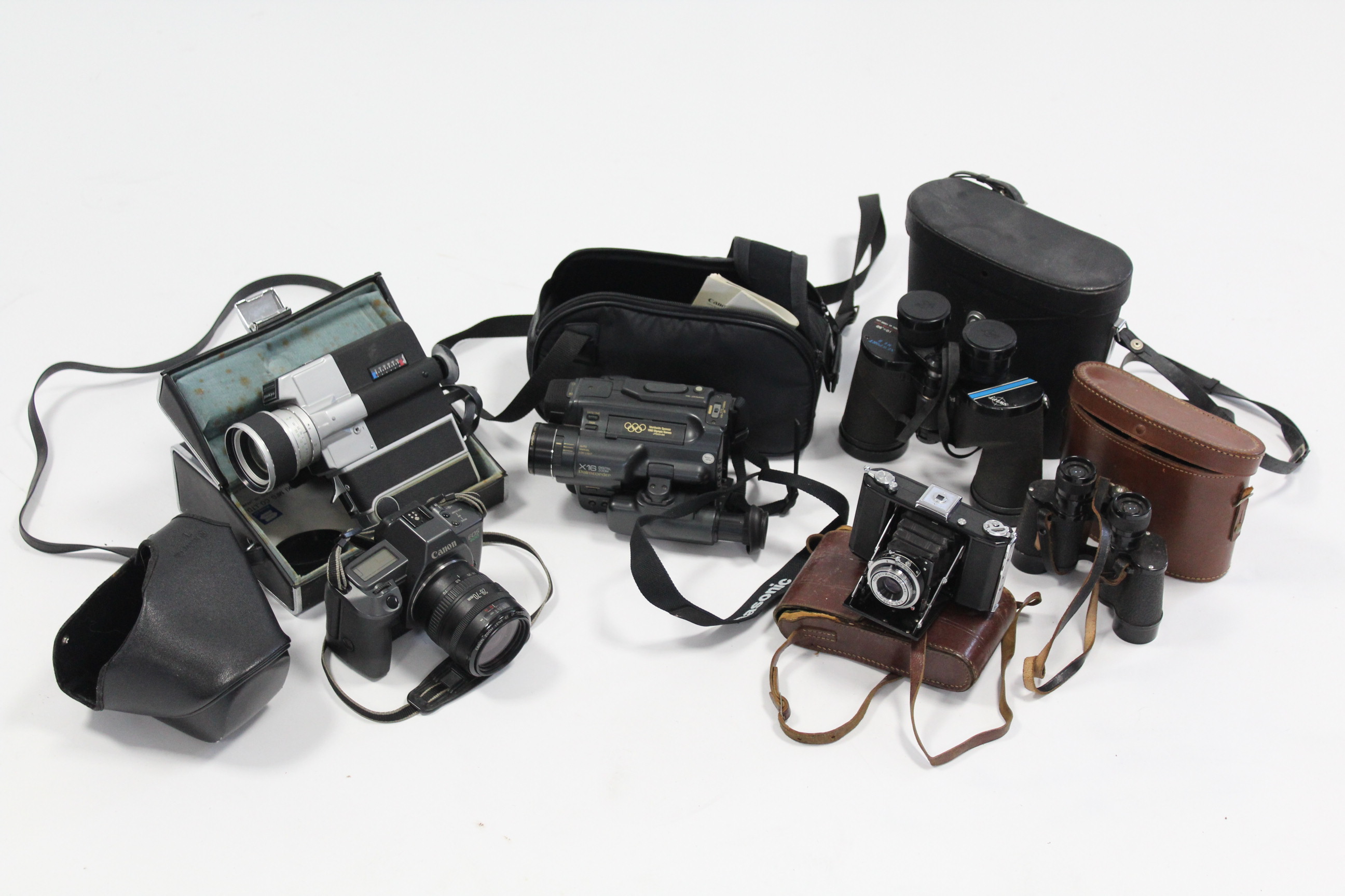 A Zeiss Ikon Nettar folding camera; a Canon “EOS 600” camera; two pairs of binoculars; & two movie