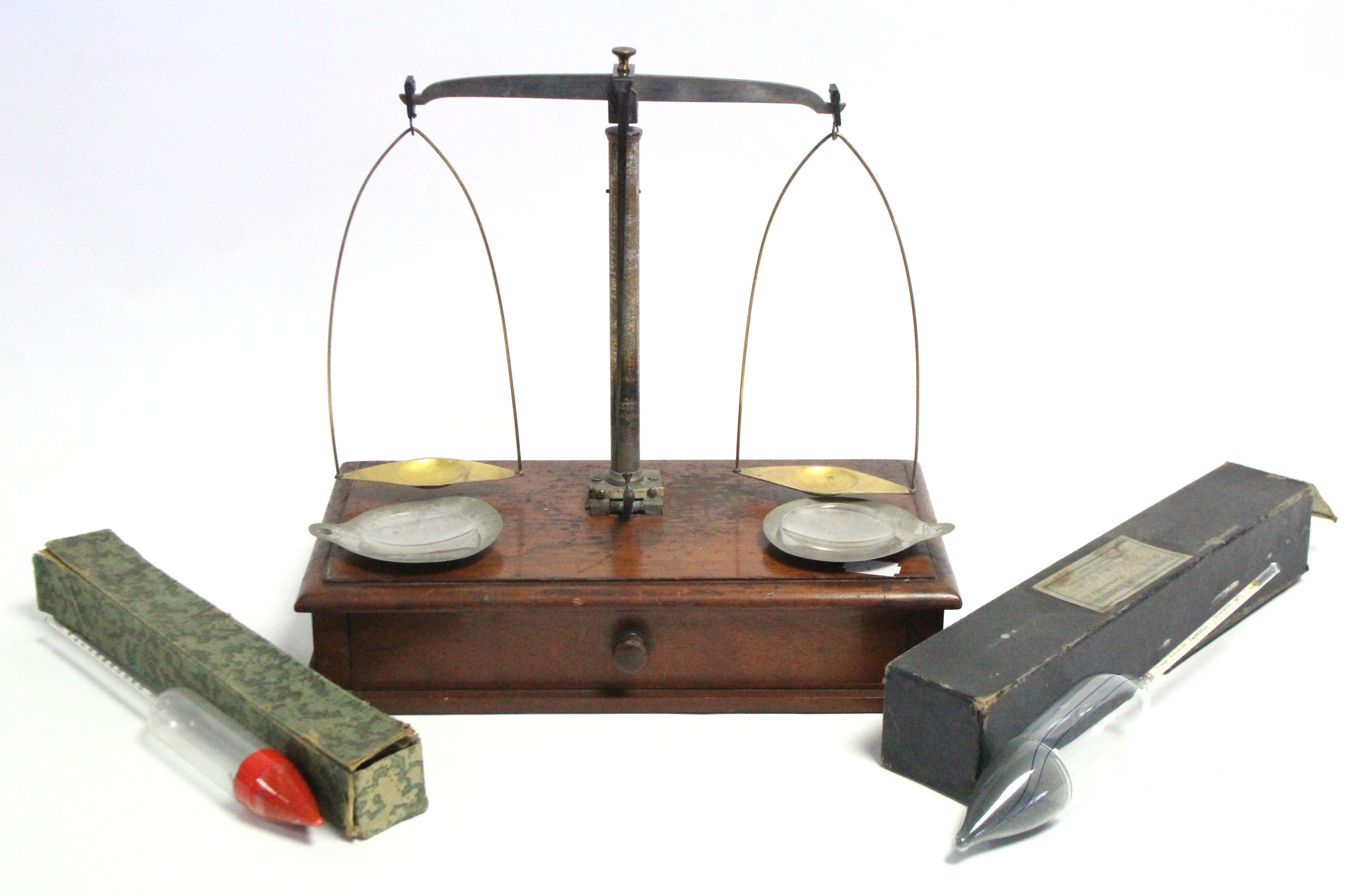 An early 20th century steel beam balance mounted on mahogany base fitted long drawer; together