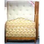 A continental-style 4’6” bedstead the head & footboard upholstered brass studded floral velour,