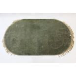 A Chinese oval rug of pale green ground & with card-cut design, 82” x 49”.