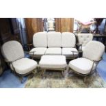 An Ercol spindle-back three-seater settee, on short round tapered legs, 69” long; three ditto