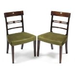 A pair of Georgian mahogany bow-back dining chairs with padded seats, & on square tapered legs.