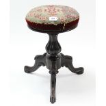 A Victorian mahogany piano stool with padded circular revolving seat, & on turned centre column &