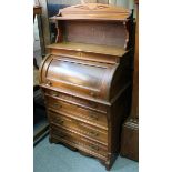 An Edwardian mahogany cylinder-front desk with open shelf to the stage back, & fitted brushing slide