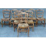 A set of eight continental-style carved oak ladder-back dining chairs with woven rush seats & on