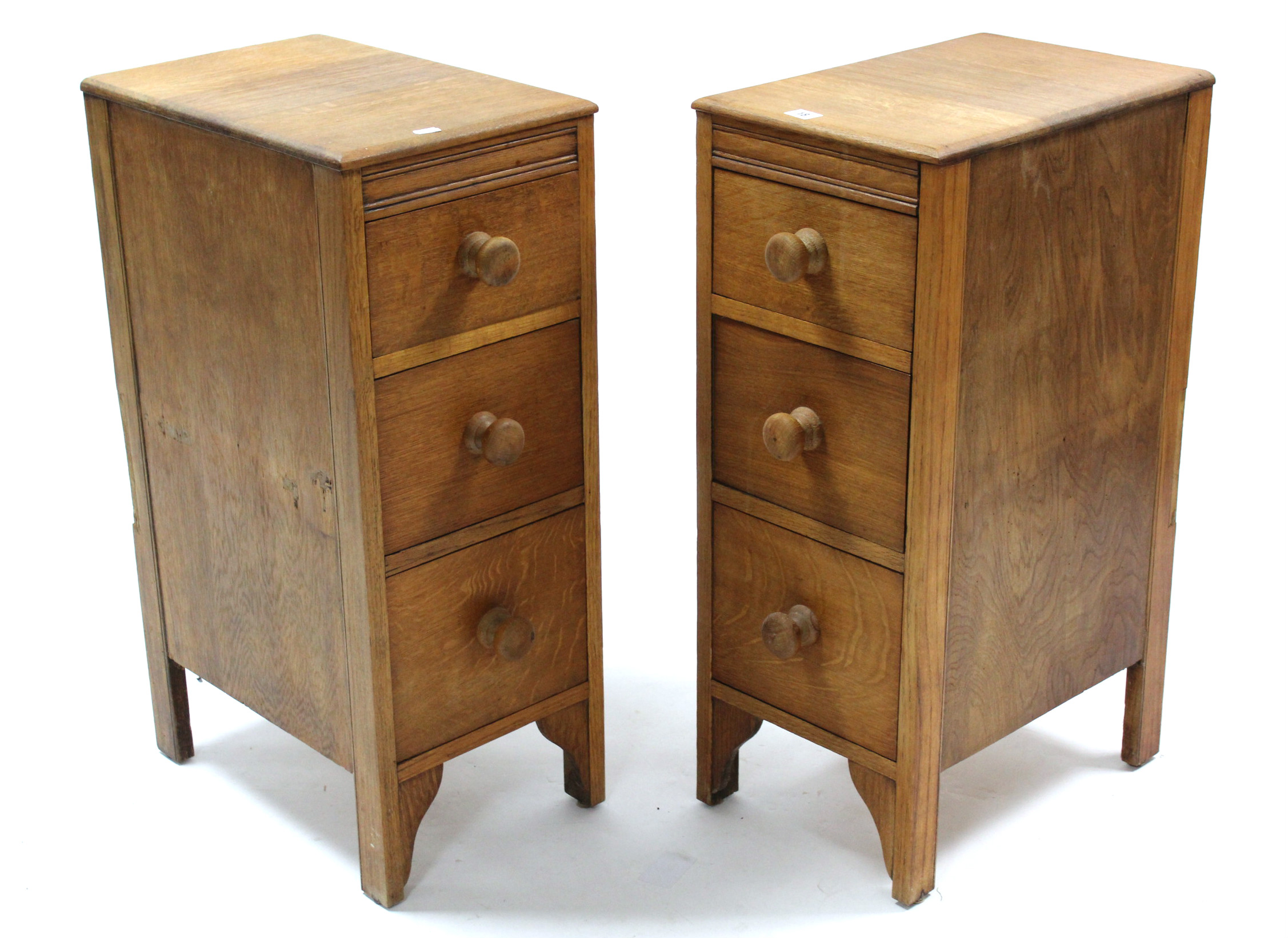 A pair of light oak three-drawer chests of narrow proportions, 12” wide x 30” high; & a light oak