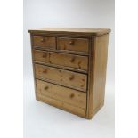 A pine & oak chest fitted two short & three long graduated drawers with turned knob handles, (slight