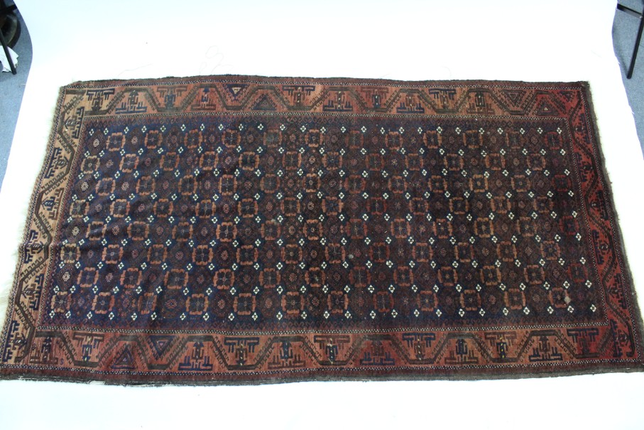 A Persian pattern rug of rust & blue ground & with all-over repeating geometric design to border