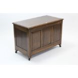 An oak coffer with hinged lift-lid, & with panelled front & sides, 37” long.