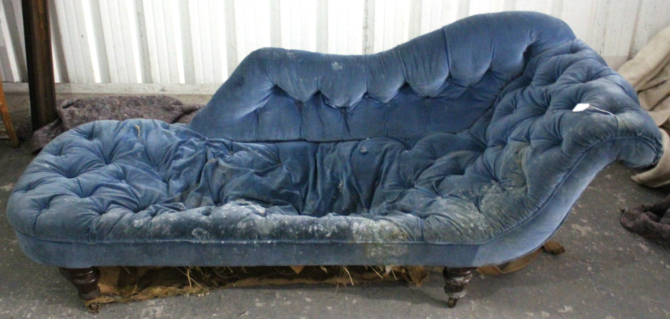 A Victorian chaise longue, upholstered buttoned blue velour, & on short turned legs with steel