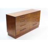 A G-PLAN SMALL TEAK SIDEBOARD, fitted two ranks of four long drawers, & on plinth base, 56” wide x