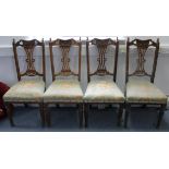 A set of four Edwardian carved oak splat-back dining chairs with padded seats, & on turned tapered