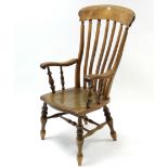 A Victorian lath-back Windsor elbow chair with hard seat, & on turned legs with turned stretchers.