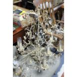 A cream finish wrought-metal eight-branch ceiling light fitting of foliate design, 22” wide x 32”