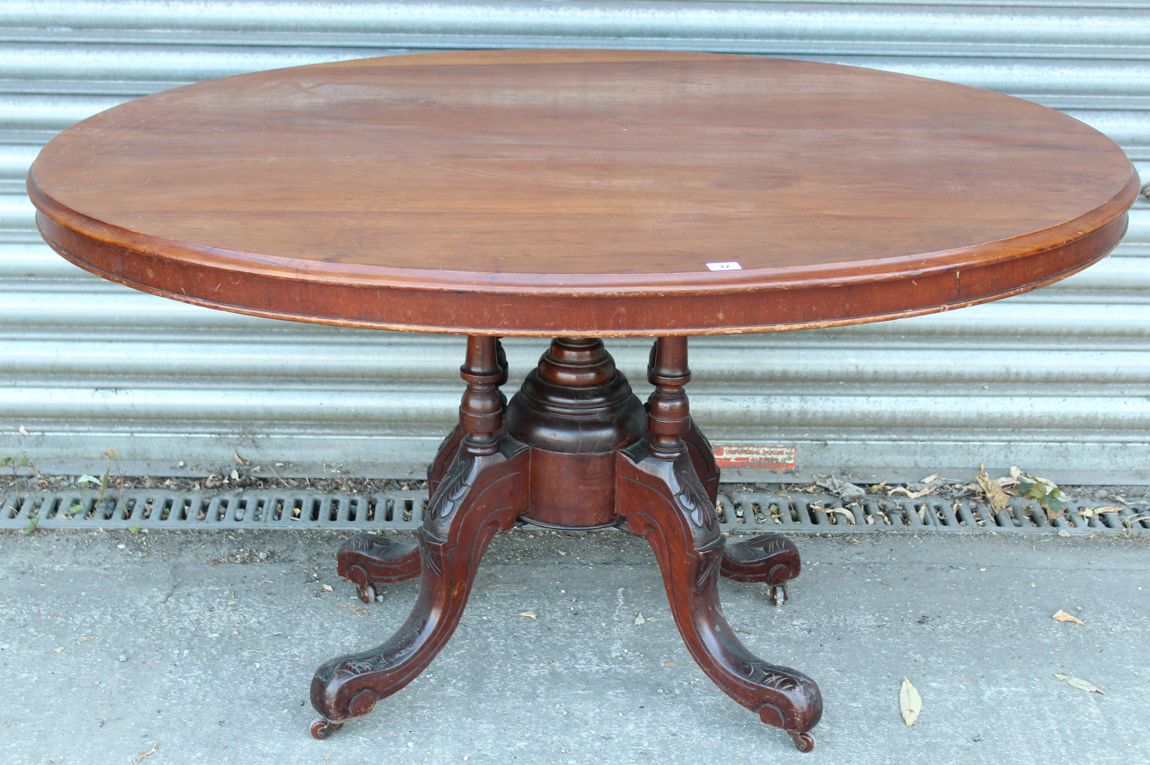 A Victorian mahogany dining table with oval tilt top, & on four turned columns & cabriole legs