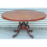 A Victorian mahogany dining table with oval tilt top, & on four turned columns & cabriole legs