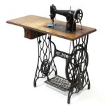 A Singer treadle sewing machine in oak case & on iron base, 30¼” wide.