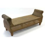A woven-cane window seat with scroll-shaped ends, & on short square tapered legs, 62” long.