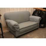 A late Victorian two-seater drop-end settee upholstered pale blue material, & on bun feet with