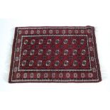 A similar Bokhara rug with three rows of eight guhls within multiple borders; 5’ x 3’5”.