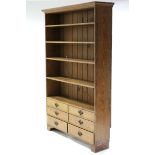 A Victorian pine bookcase fitted five shelves with six graduated drawers below, on ogee bracket