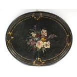 A Victorian oval papier mâche tray painted with a bouquet of flowers on a black ground within gilt