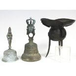 An Indian brass ceremonial bell, with all-over relief decoration, the handle forming the head of a