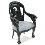 A 19th century ebonised armchair, all-over carved with scene of George and the Dragon to the rounded