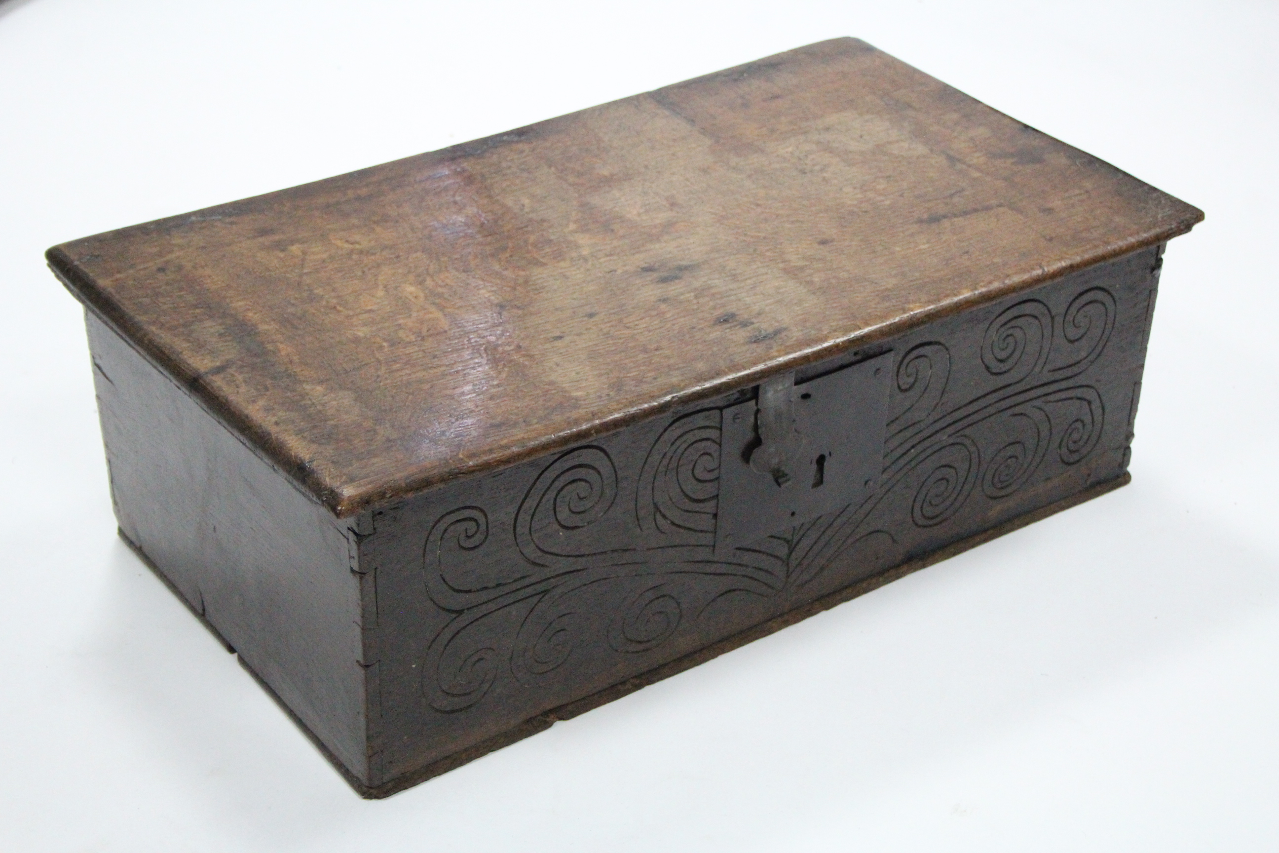 A late 17th century oak Bible box with hinged lid & naïve carved scroll decoration to the front; 26”