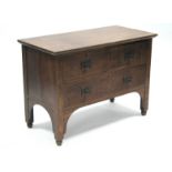 An Arts & Crafts oak chest fitted two short & one long drawers, the iron ring-handles with shaped