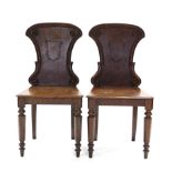 A pair of Victorian pollard-oak hall chairs, the shaped backs with applied shell motif & rosettes, &