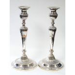 A pair of Sheffield candlesticks with part-reeded round tapered columns on circular bases; 12½”