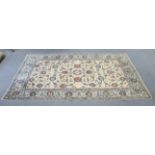 A Persian carpet of ivory & blue ground, with all-over decoration of floral spandrels within