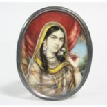 A 19th century Indian portrait miniature of a young noblewoman holding a rose; 2½” x 2” (oval).