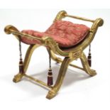 A regency-style giltwood stool, the carved & reeded ‘X’ frame joined by turned stretchers, & on