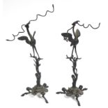 A pair of 19th century bronze models of cranes, each holding two serpents in their beaks atop oak