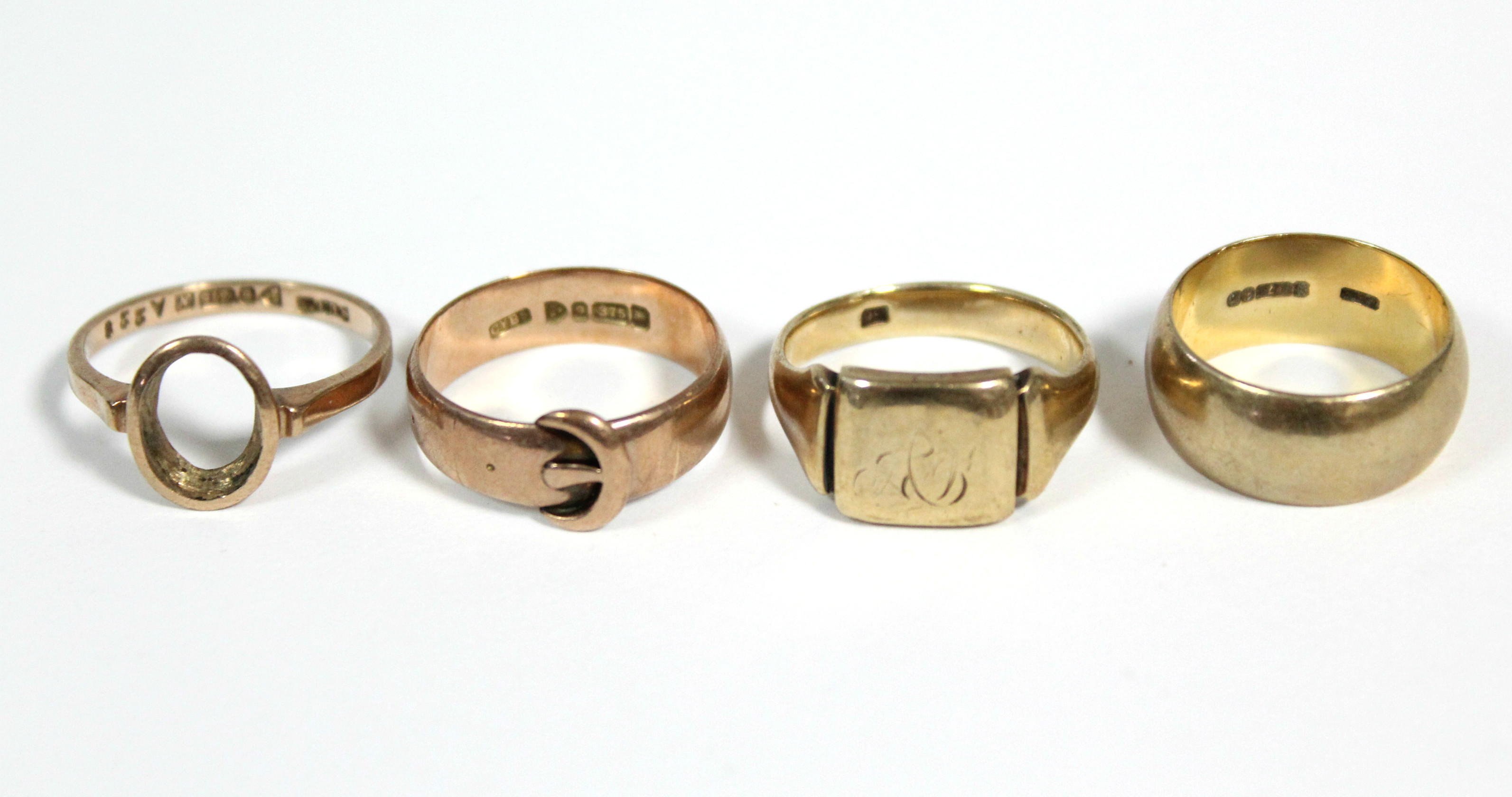 A 9ct. gold wedding band; a ditto signet ring; a ditto belt buckle ring; & a ditto dress ring –