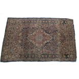 A Persian rug of deep blue & crimson ground with central medallion surrounded by floral spandrels