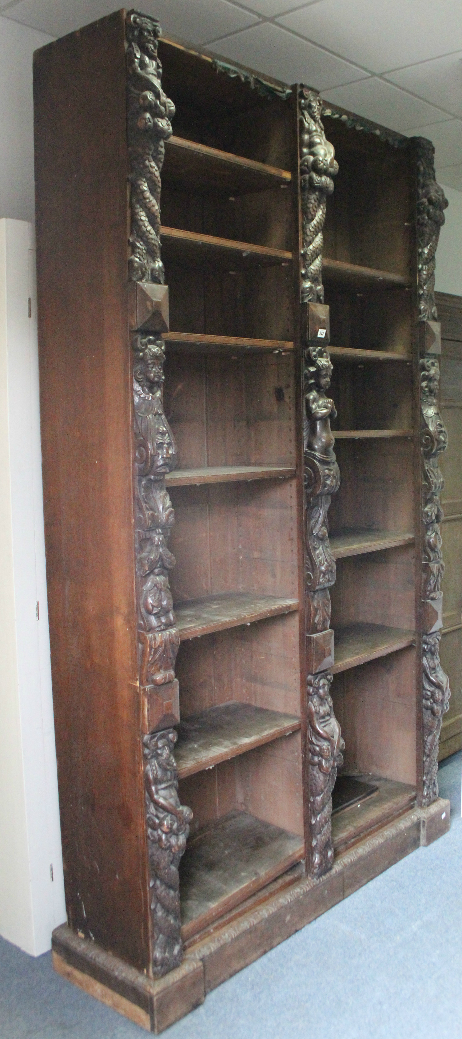 A Victorian oak tall standing open bookcase fitted fourteen adjustable shelves, and heavily carved