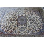 A Persian carpet of ivory & pale blue ground, with central medallion surrounded by floral spandrels,