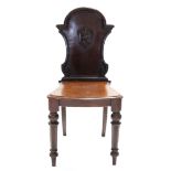 A Victorian mahogany hall chair, the shaped back with applied shell motif, shaped seat, & on