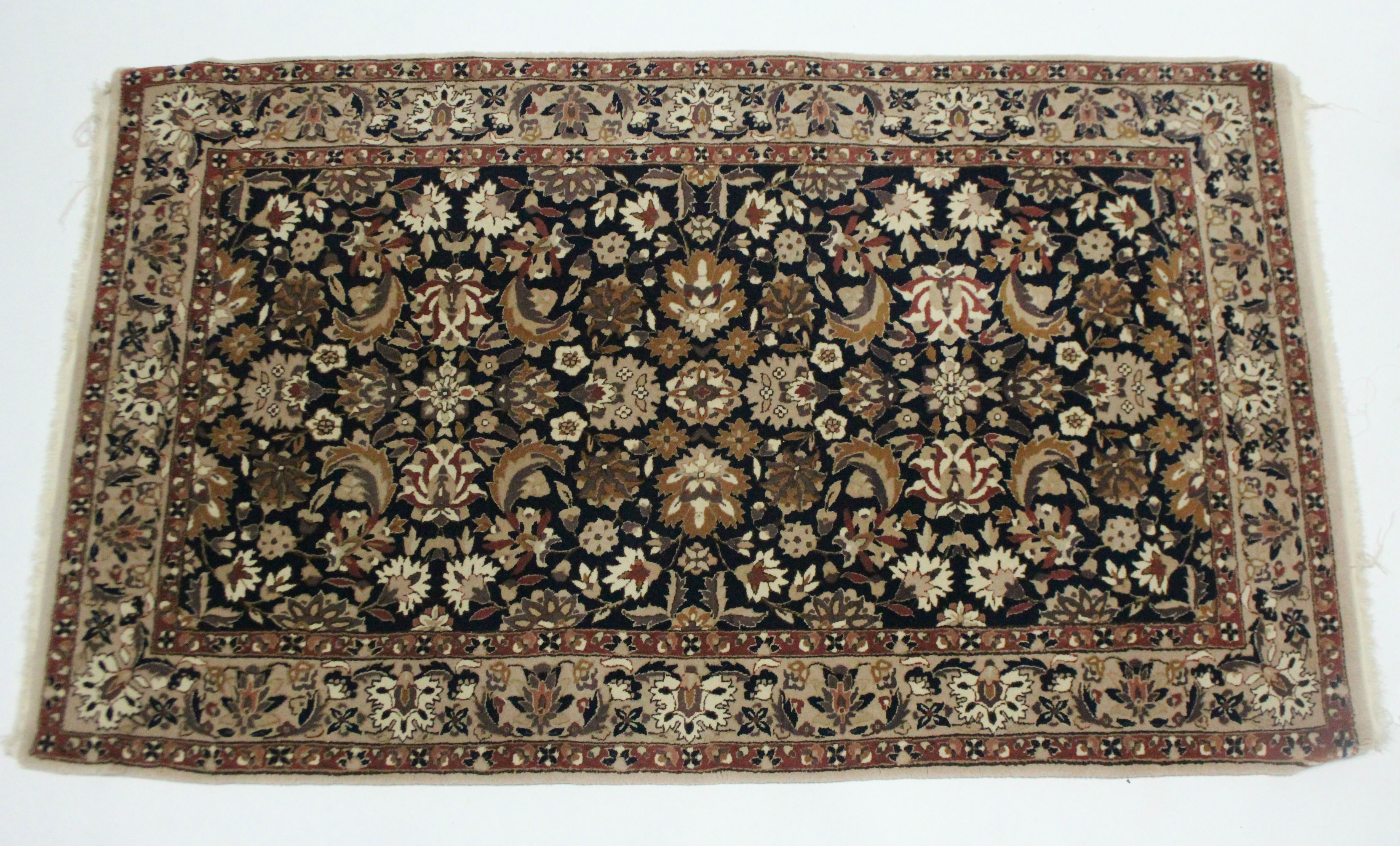 A Persian rug of deep blue & fawn ground, all-over decorated with floral spandrels within multiple