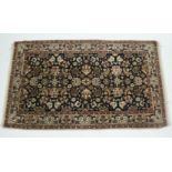 A Persian rug of deep blue & fawn ground, all-over decorated with floral spandrels within multiple