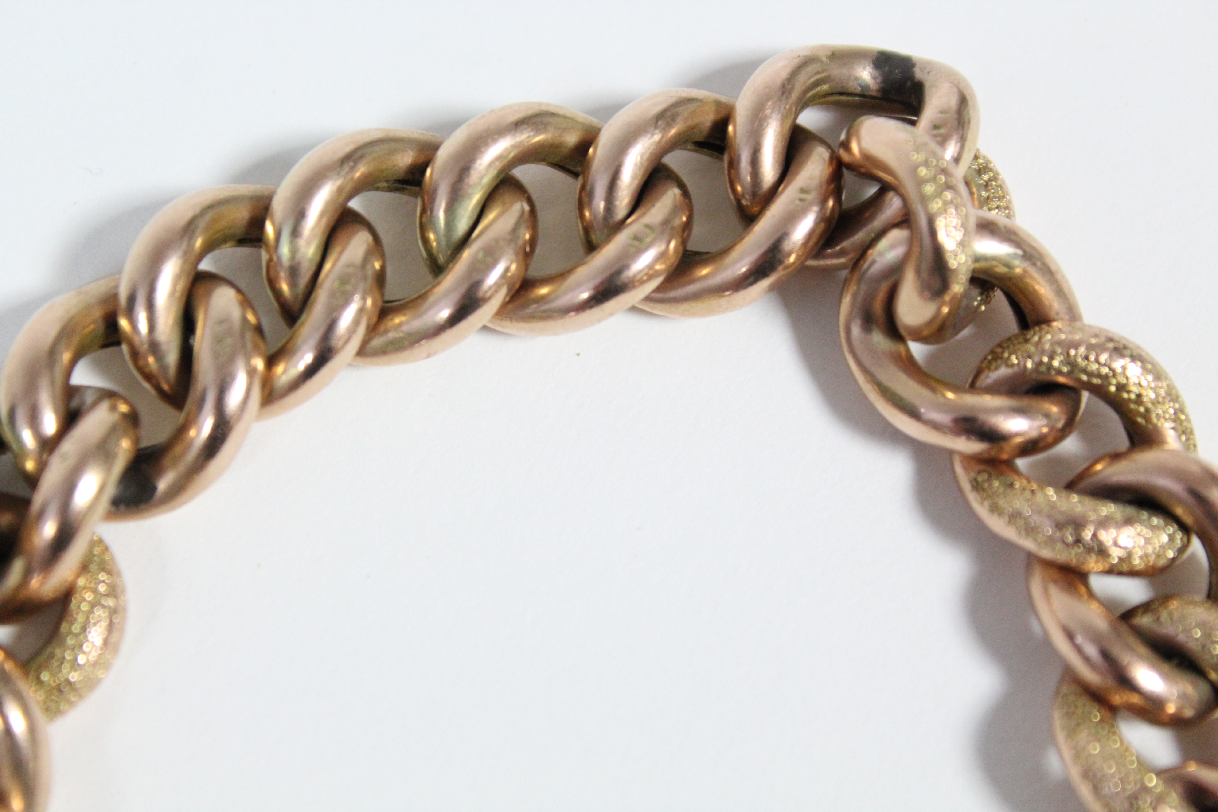 A 9ct. gold bracelet of large hollow textured curb links, with padlock clasp & safety chain. (30. - Image 2 of 3