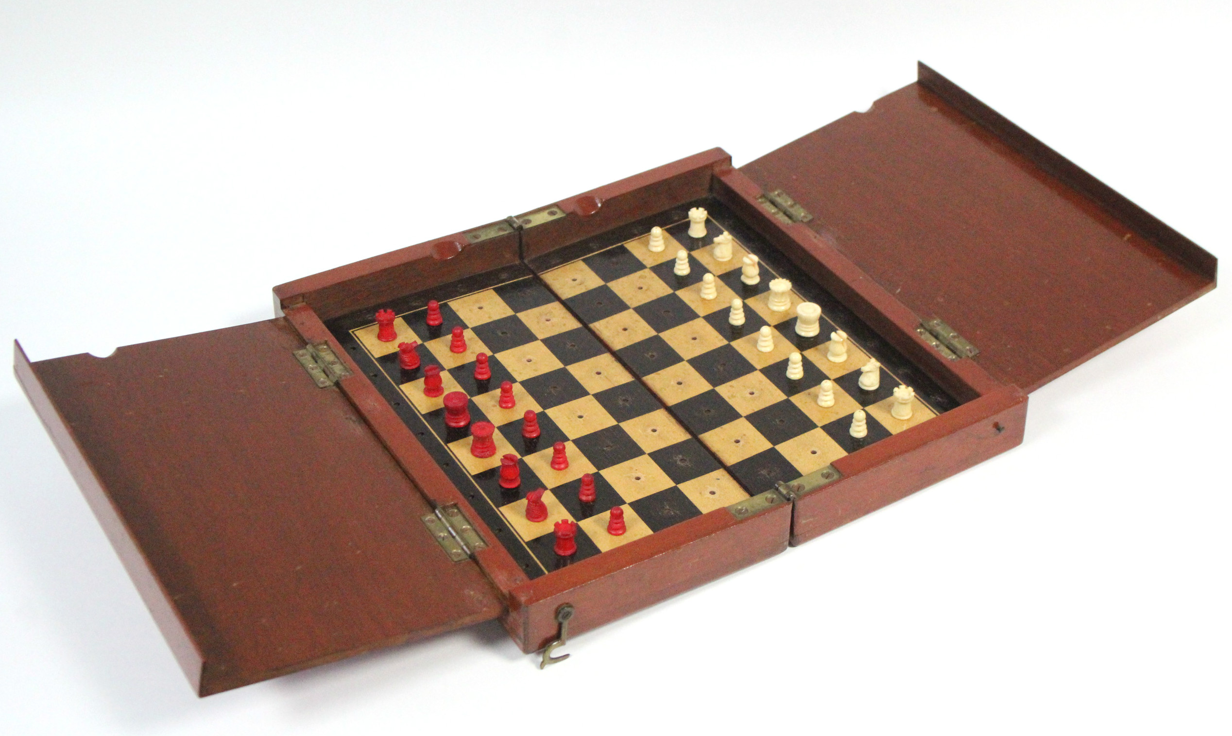 A late 19th century travelling ivory chess set of natural & red stain, height of Kings ½”, in