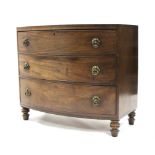 An early 19th century mahogany bow-front chest, in two sections, fitted three graduated drawers with